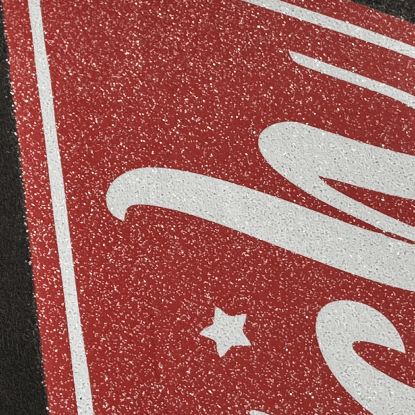 Close up picture of glitter dtf on red image.