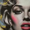 A close-up of a detailed DTF-printed design featuring a stylized portrait of a woman with bold red lips, dramatic eye makeup, and golden highlights in her hair. The artwork has a realistic, high-contrast look with graffiti-style elements in the background, showcasing the vibrant colors and fine detail achievable with DTF printing. direct to film