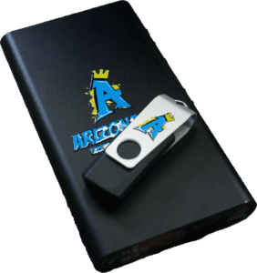 UV DTF sticker transfers applied to a black portable charger and a white swivel USB flash drive. The stickers feature a vibrant blue 
