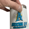 A hand peeling the clear film off a UV DTF sticker transfer applied to a white tumbler. The sticker features a bold blue "A" logo with a gold crown and "Arizona Ink Custom Print Solutions" in a graffiti-style font. The high-gloss, raised ink finish is visible, showcasing the application process of UV DTF transfers on hard surfaces.